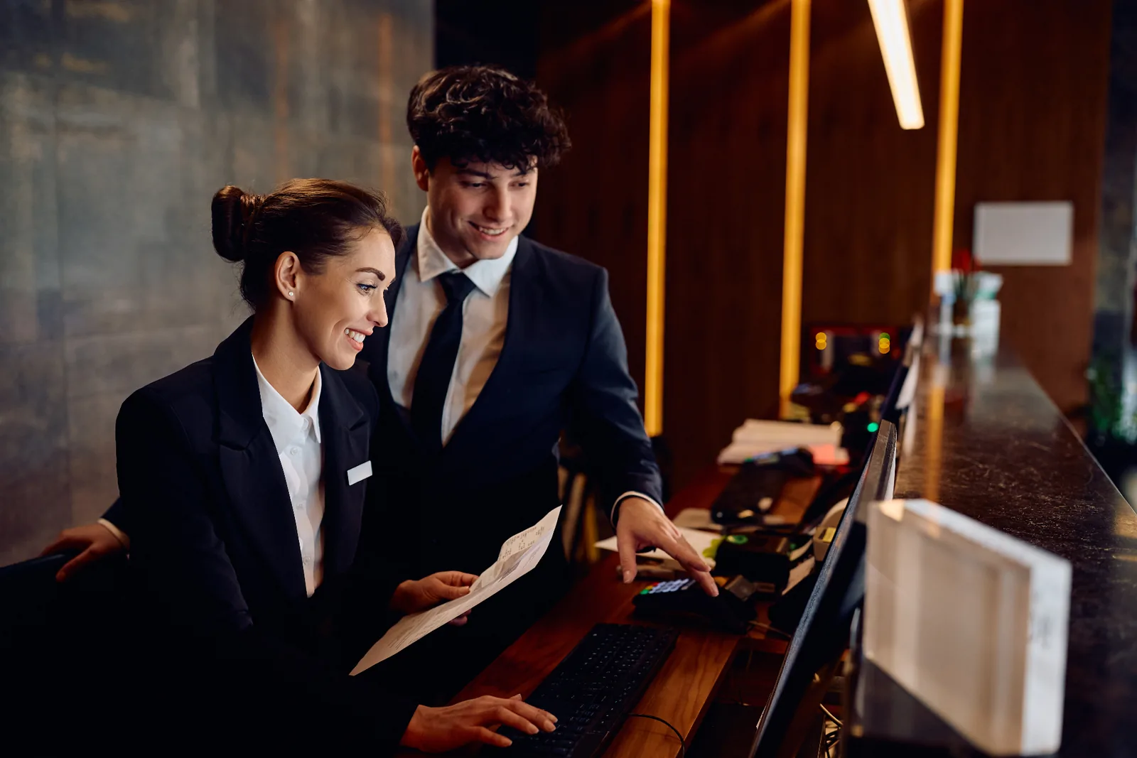 Hotel front-desk staff using a payment terminal at reception
